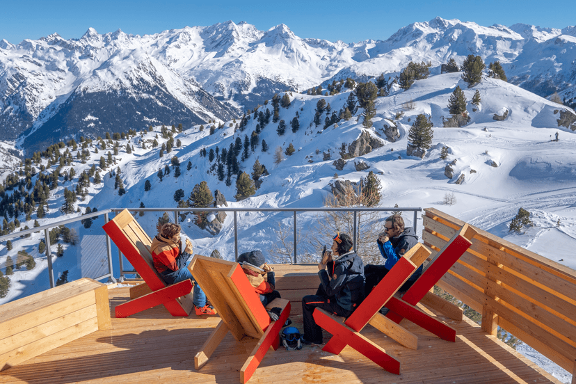Family of skiers taking a break to eat lunch above Les Arcs ski resort